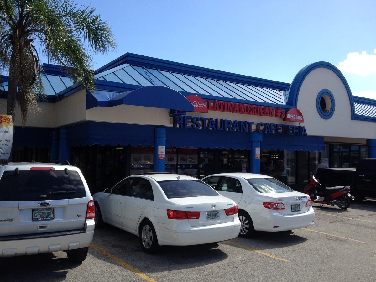 Blue commercial fabric canopy at a Latin American restaurant cafeteria entrance, blue Spanish-style awning trim.